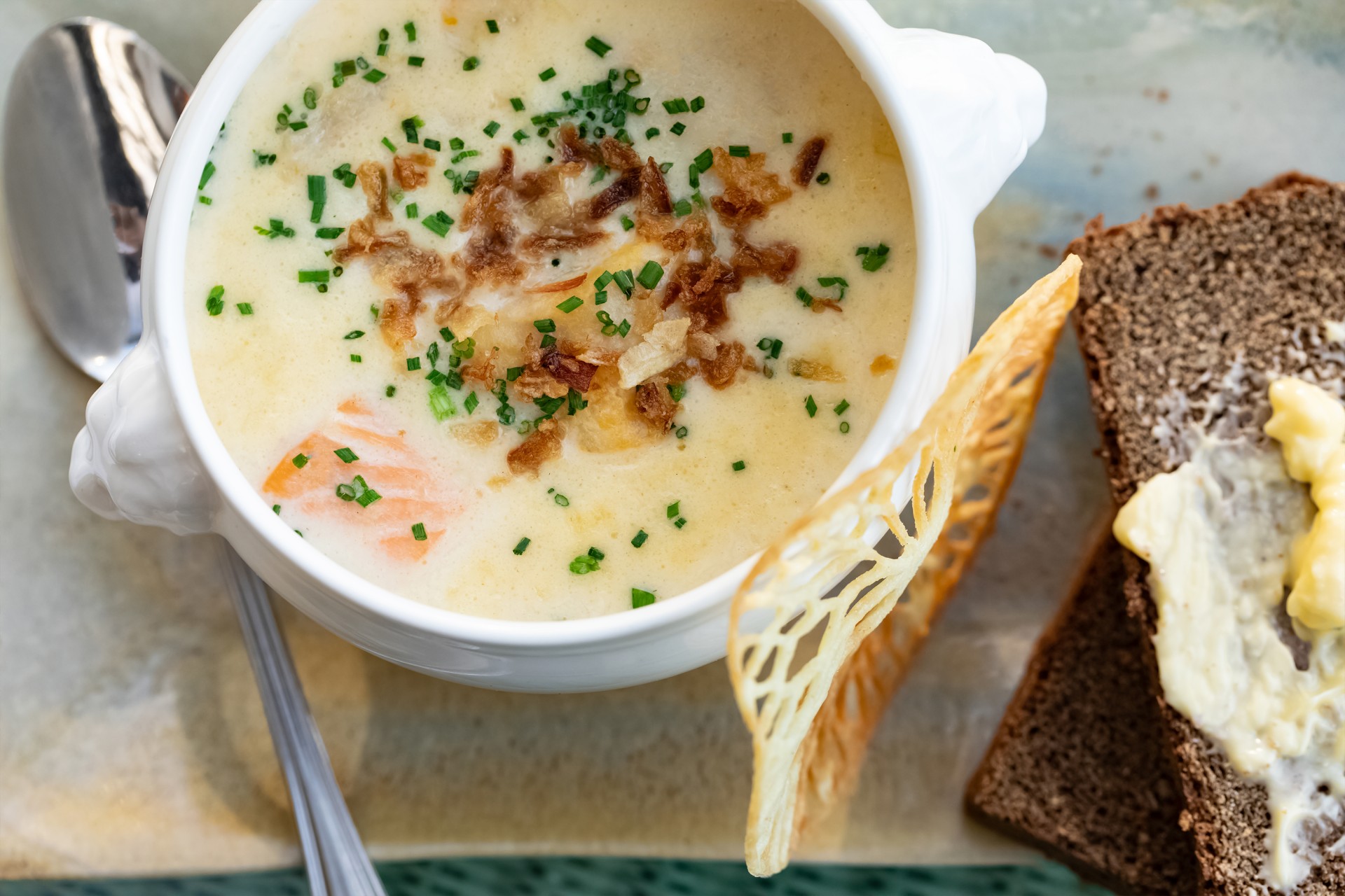 a bowl of soup with bread and a fork