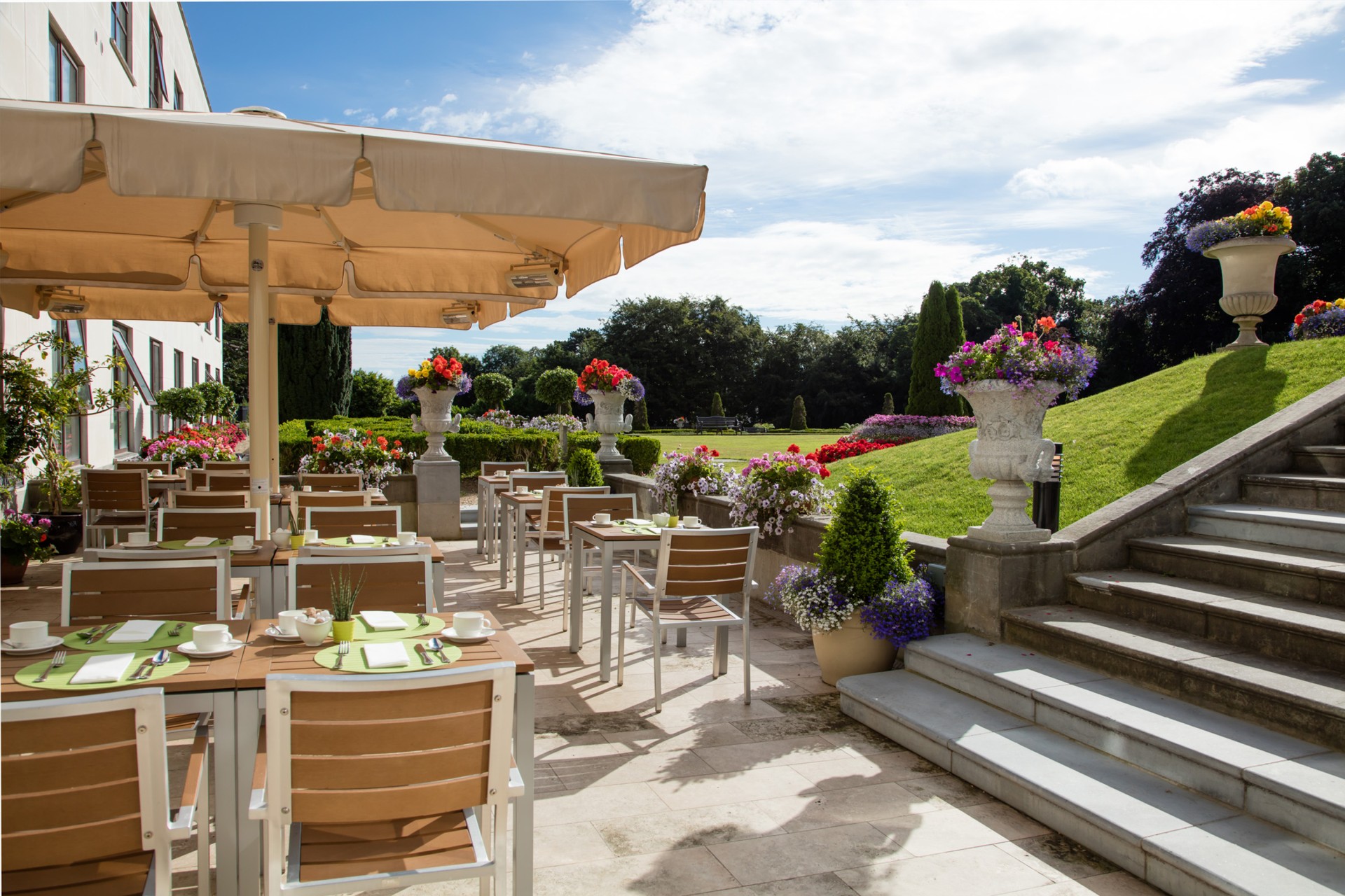 a patio with tables and chairs and flowers