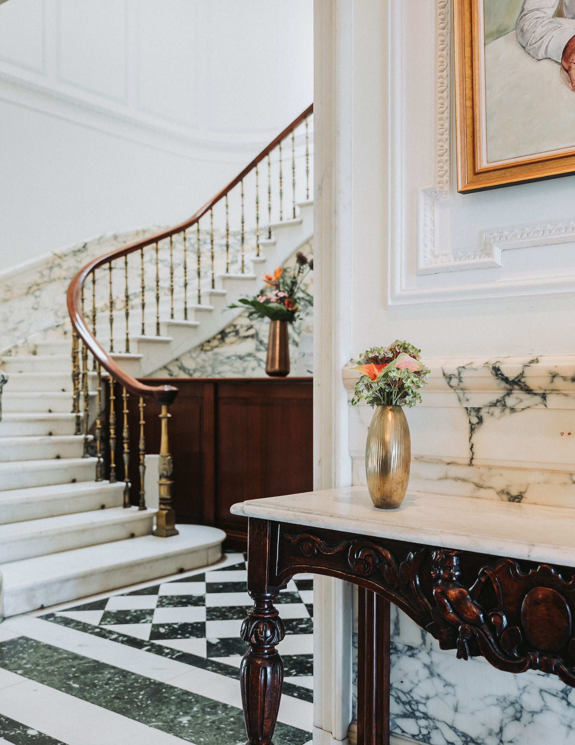 a marble staircase with a vase of flowers