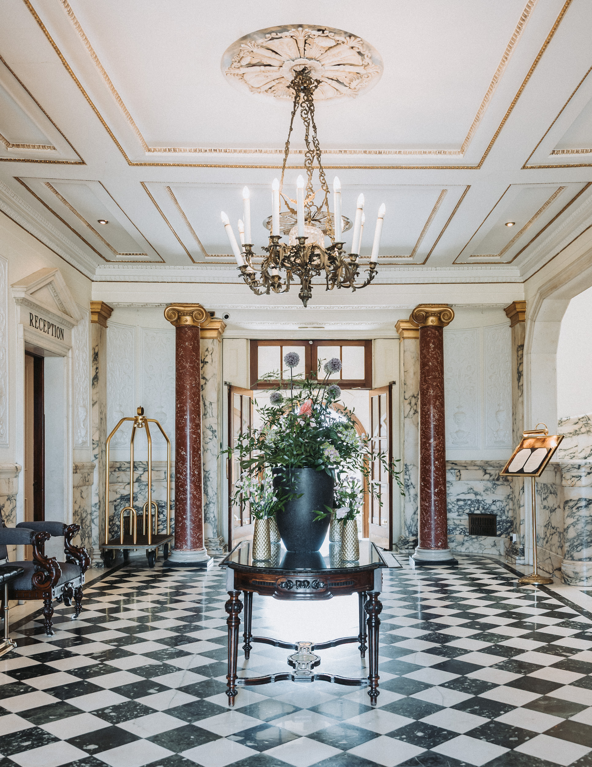 a room with a black and white checkered floor and chandelier