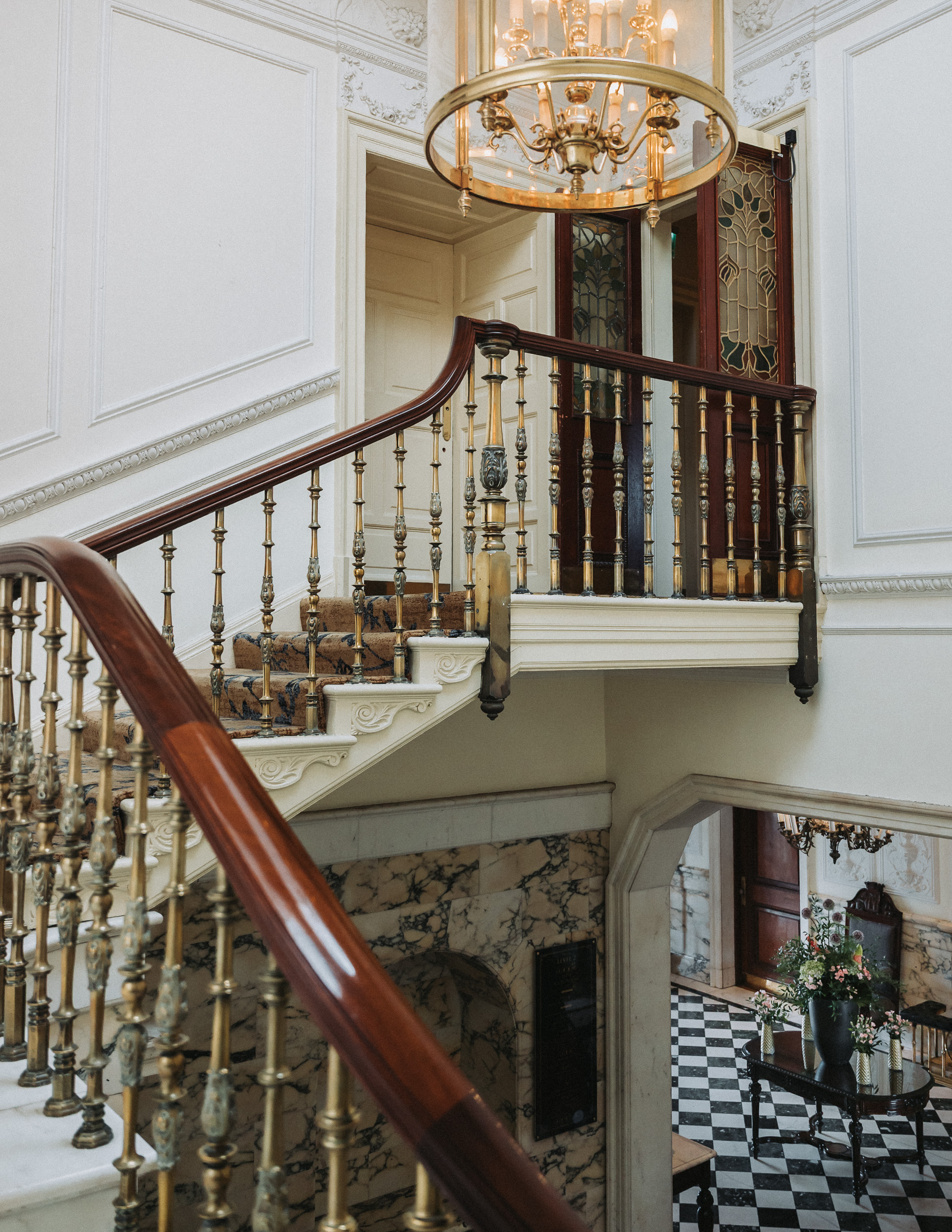 a staircase with a chandelier and a marble floor