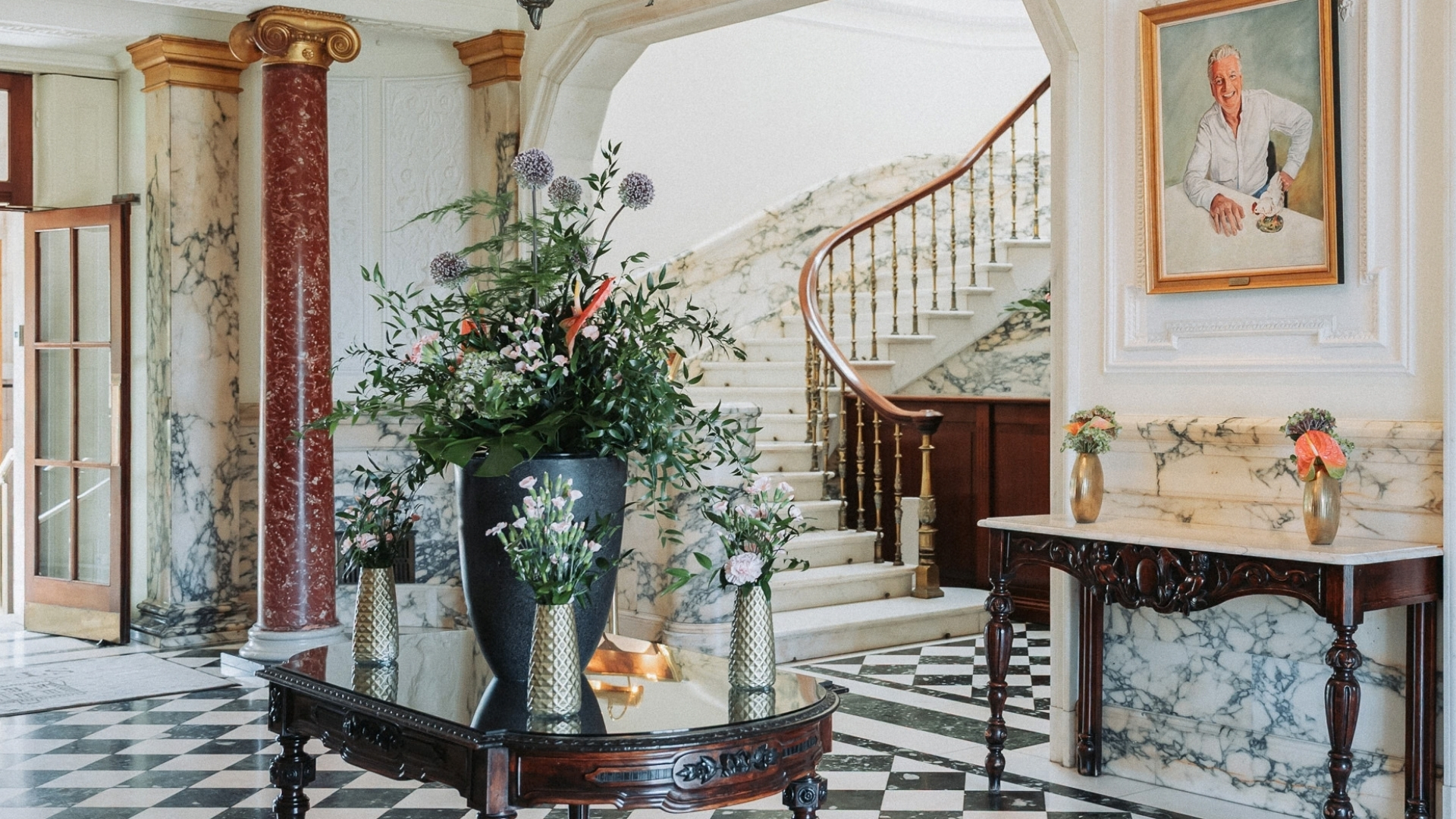 a vases of flowers on a table in a foyer