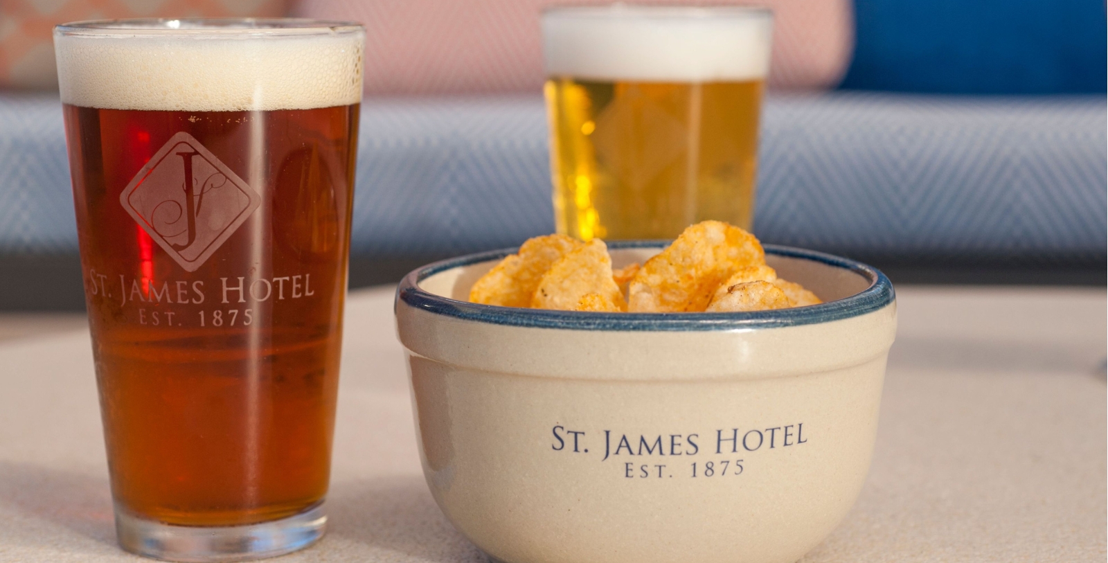 a bowl of potato chips next to a glass of beer