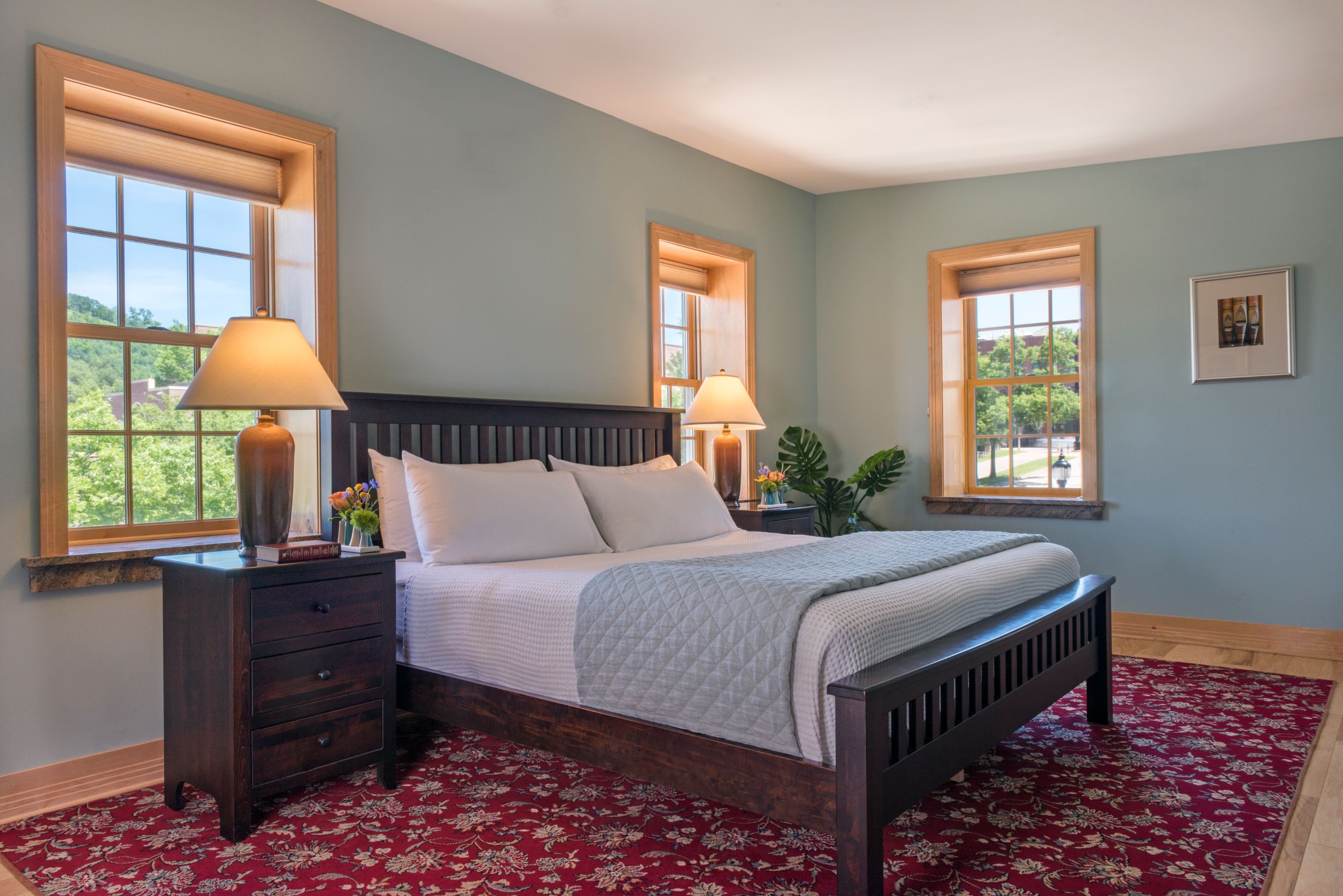 a bed with a red carpet and lamps