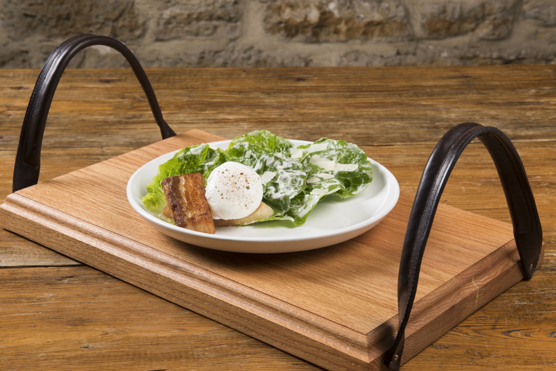 a plate of salad on a wooden tray