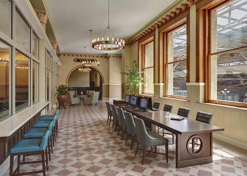 a long table with chairs in a room with windows