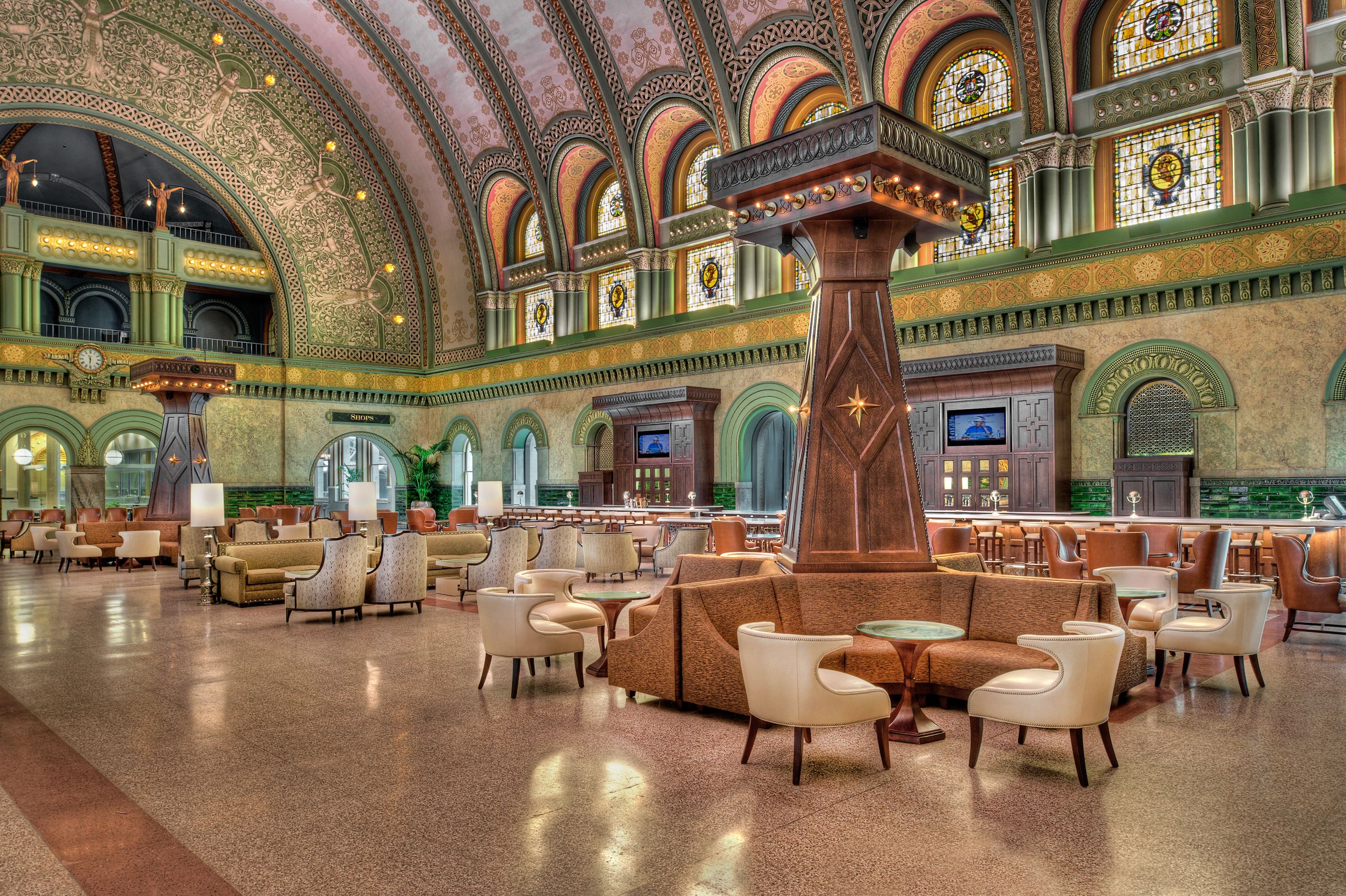 a large room with a large column and tables and chairs