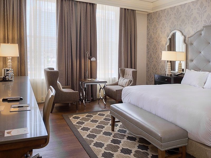 a room with a bed and a desk and chairs