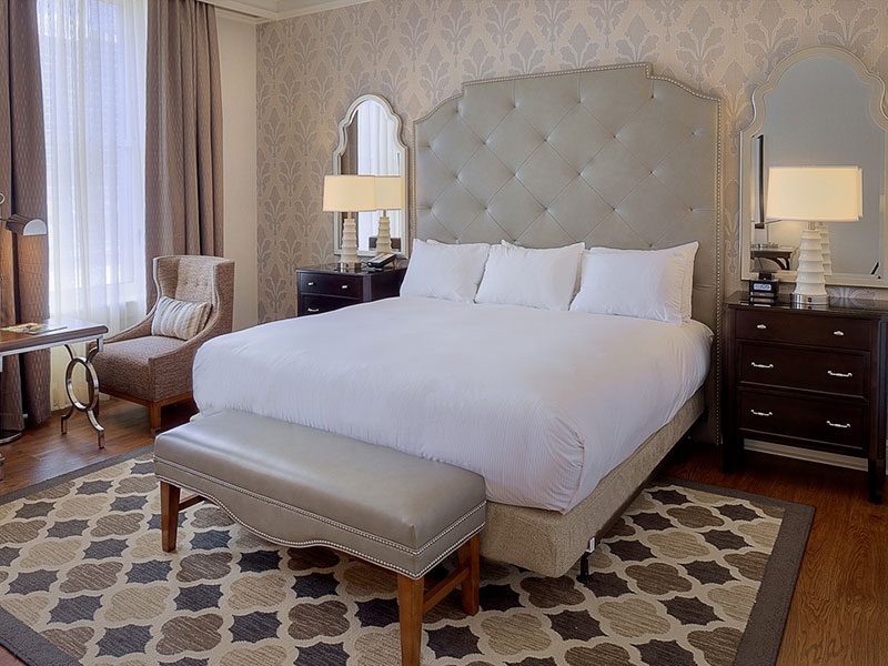 a bed with a foot board and a chair in a room