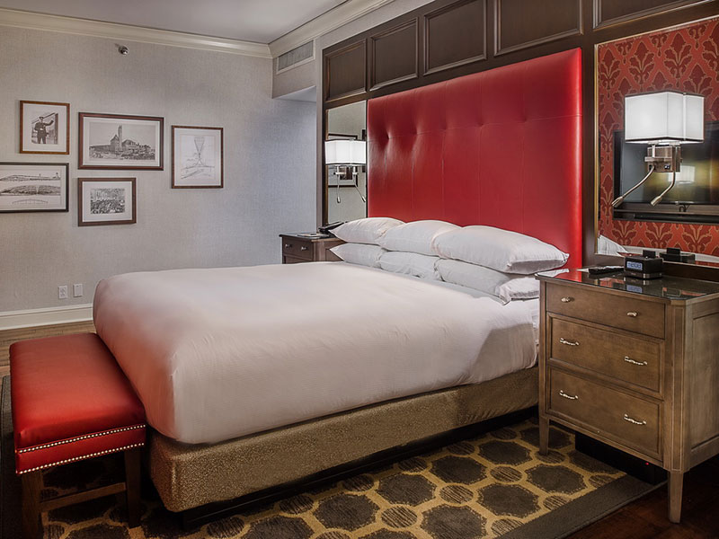 a bedroom with a red headboard and a mirror