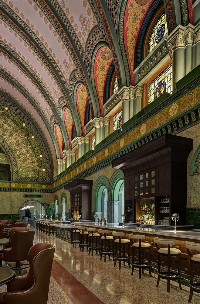 a large ornate room with a bar and chairs