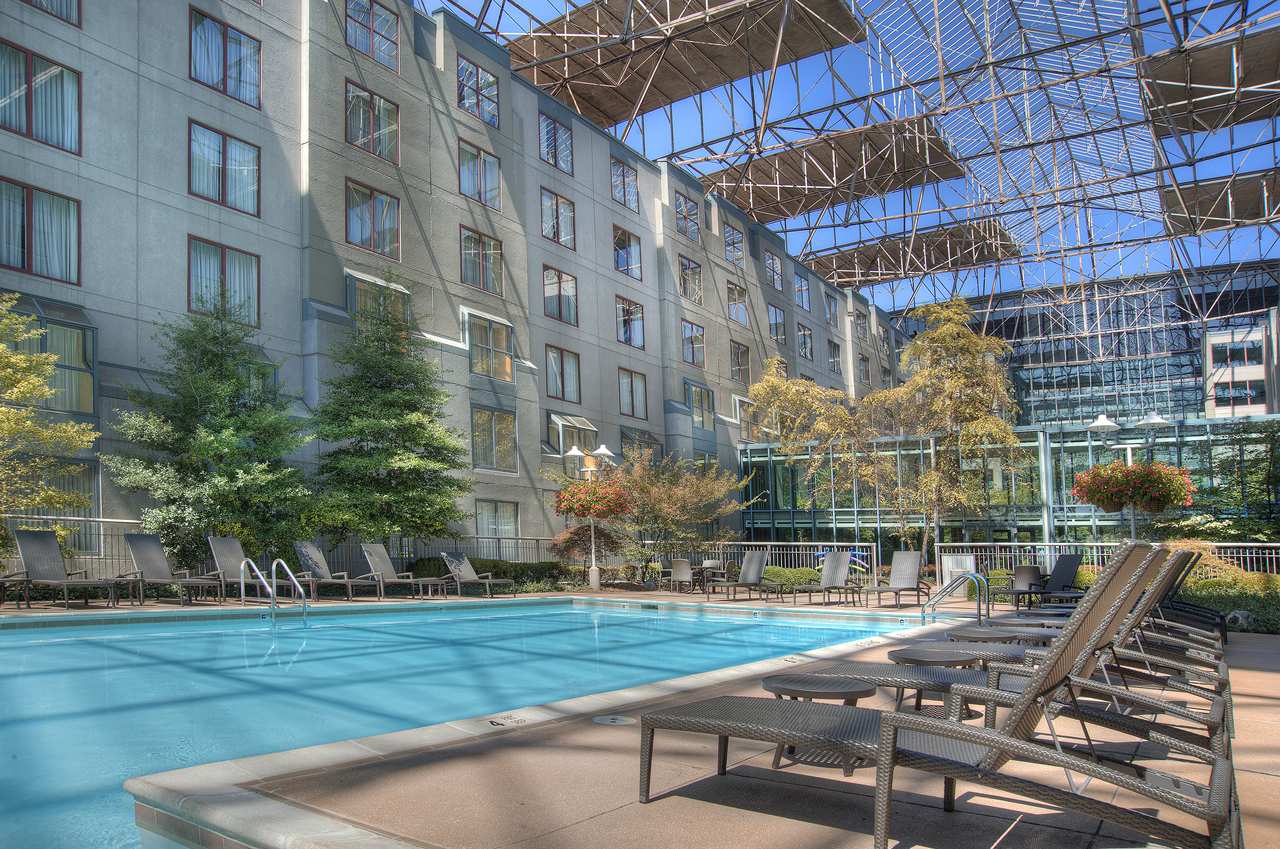 a pool with lounge chairs and a building