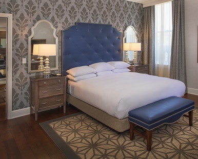 a bed with a blue headboard and a blue ottoman