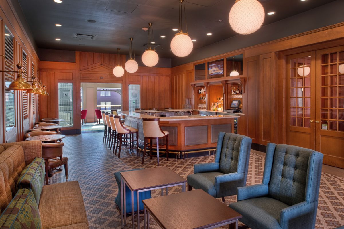 a room with a bar and chairs