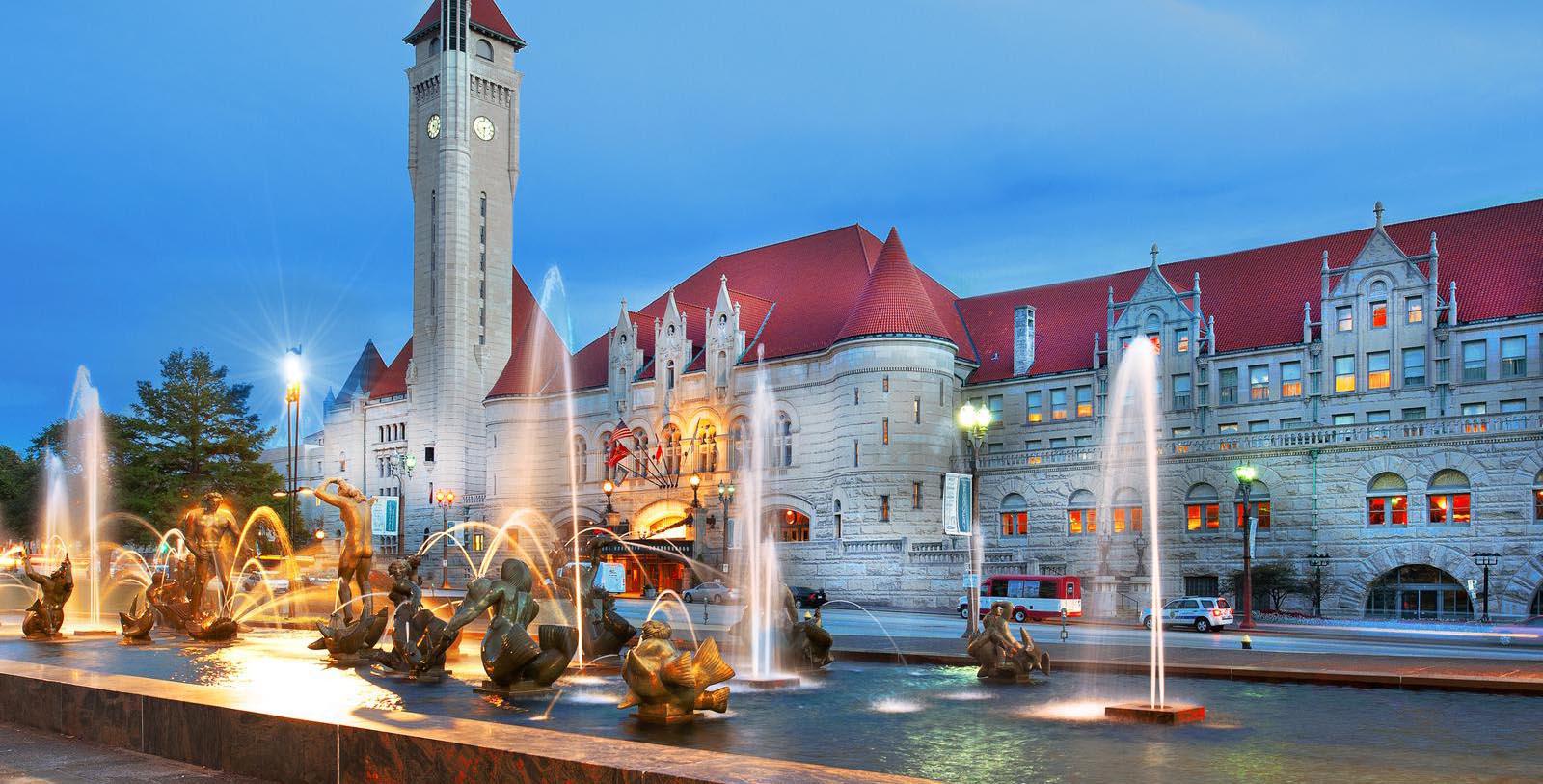 a large building with a clock tower and fountain