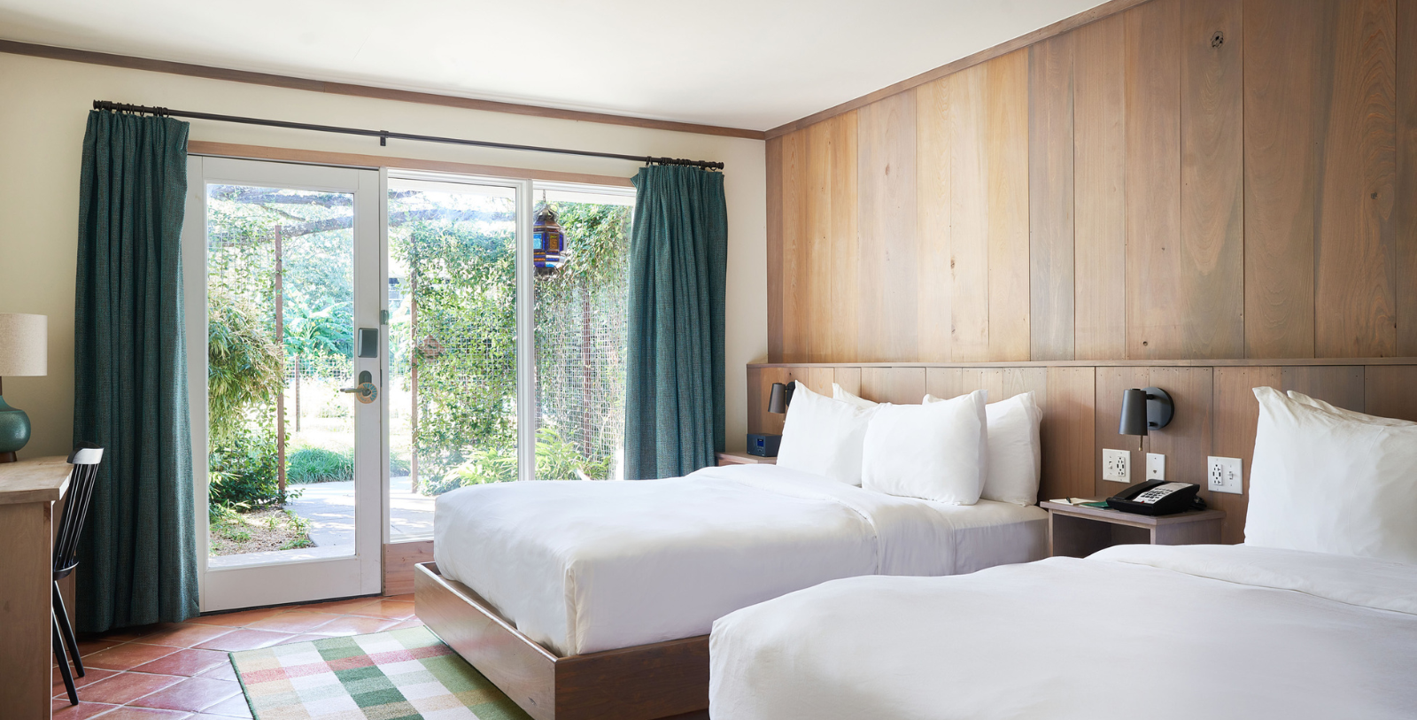 a room with two beds and a glass door