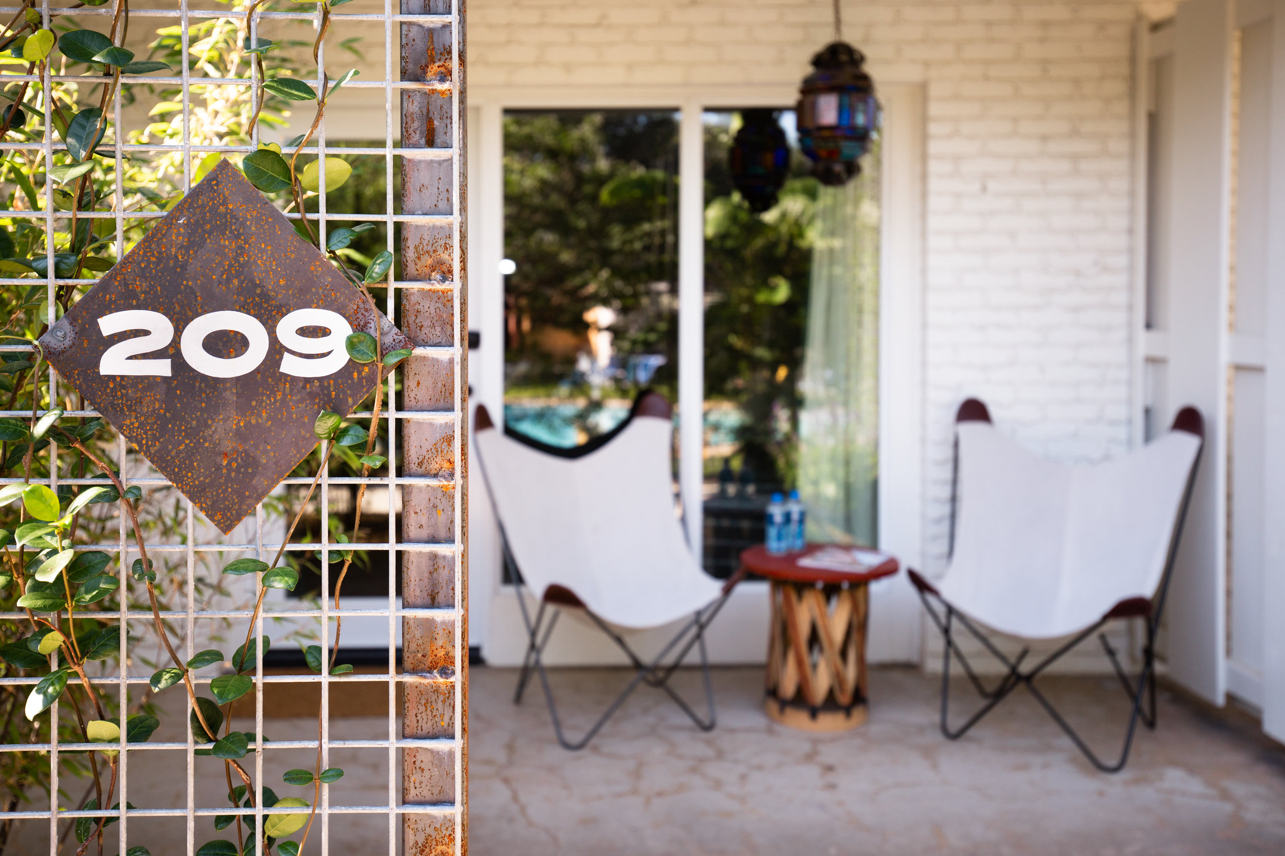 a metal fence with chairs and a table in front of a house