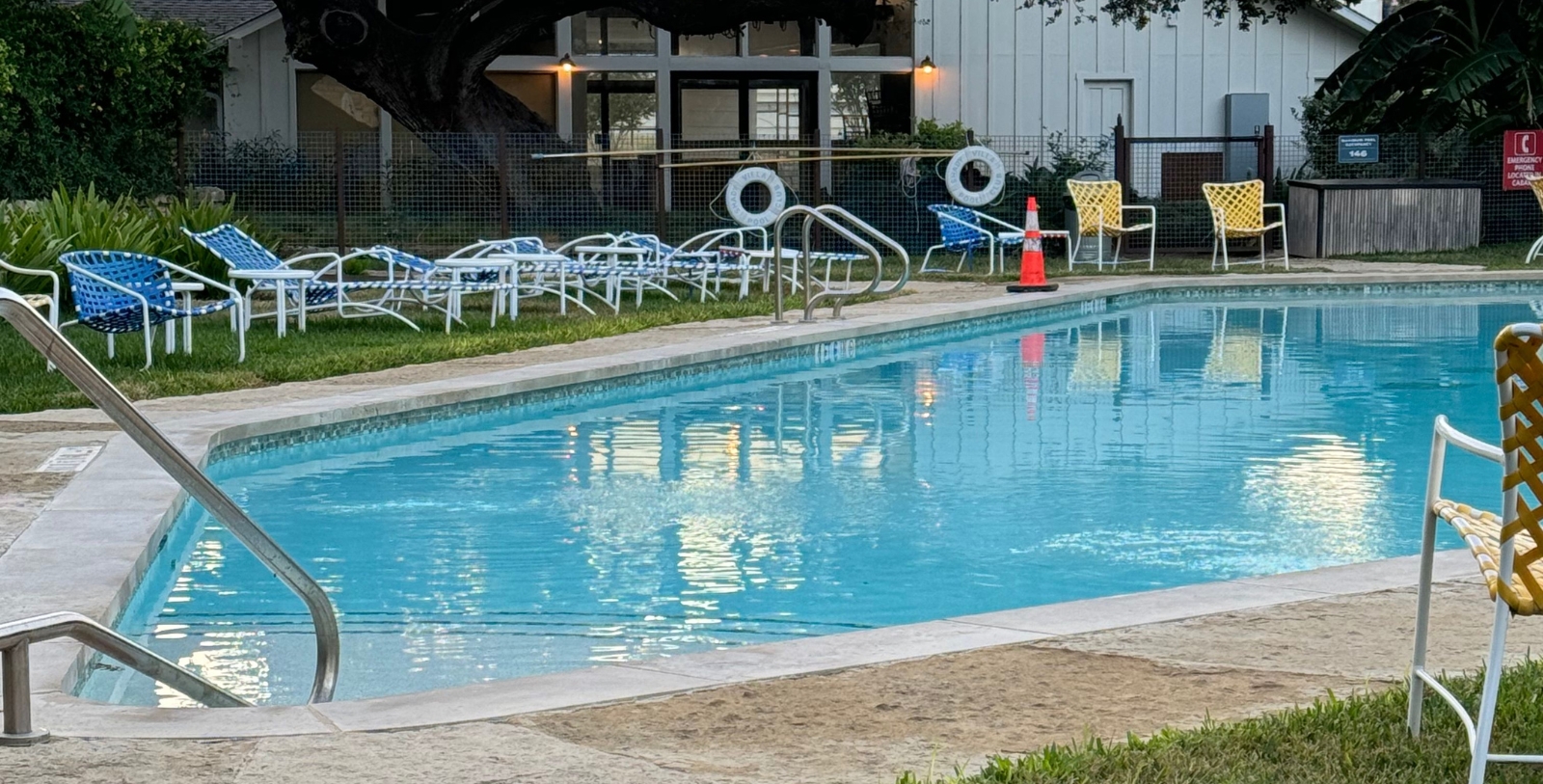 a pool with chairs and a fence