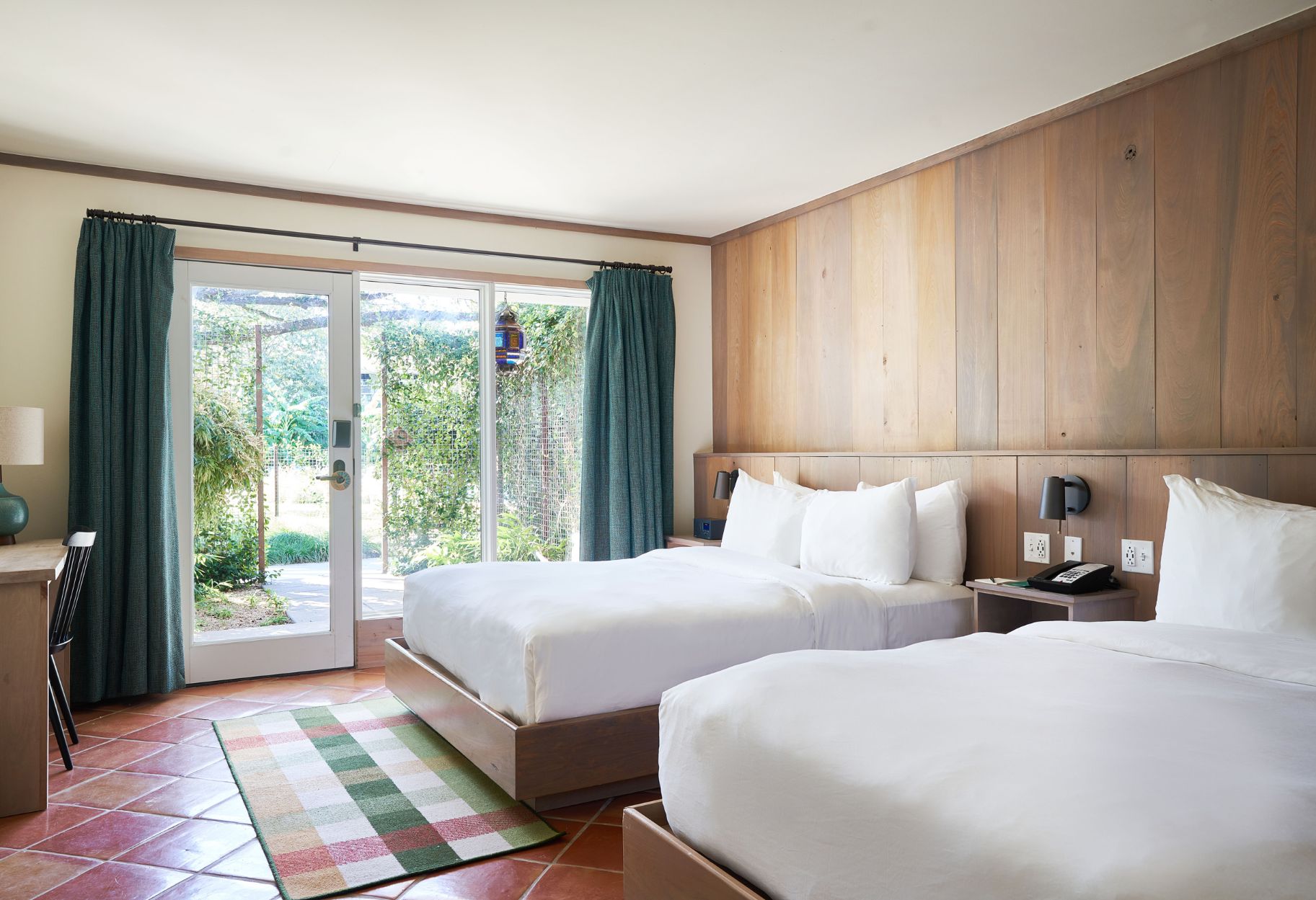 a room with two beds and a glass door
