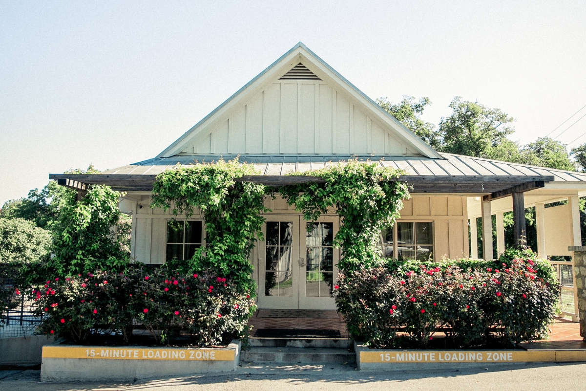 a house with flowers and a sign