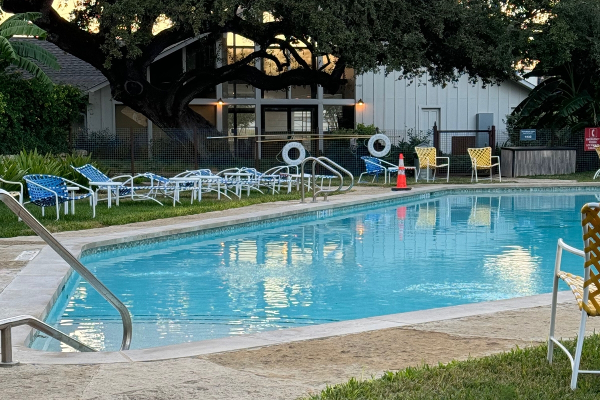 a pool with chairs and a building