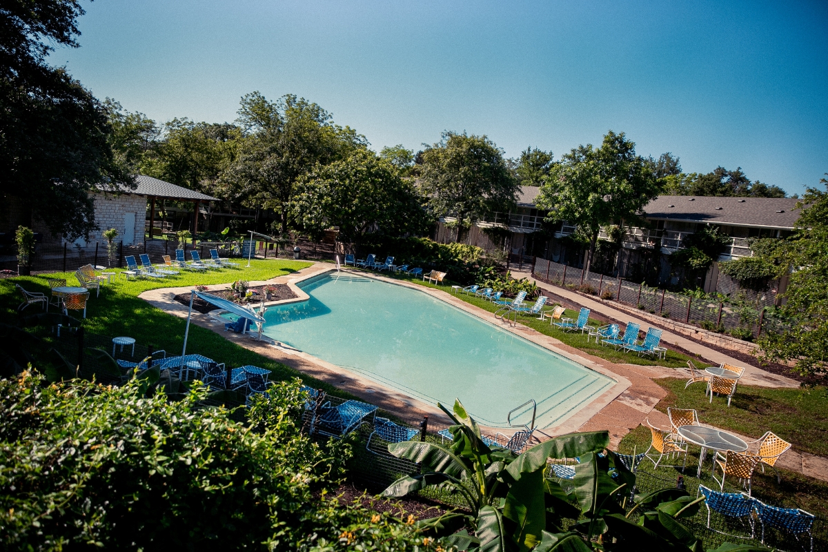 a pool with chairs and trees around it