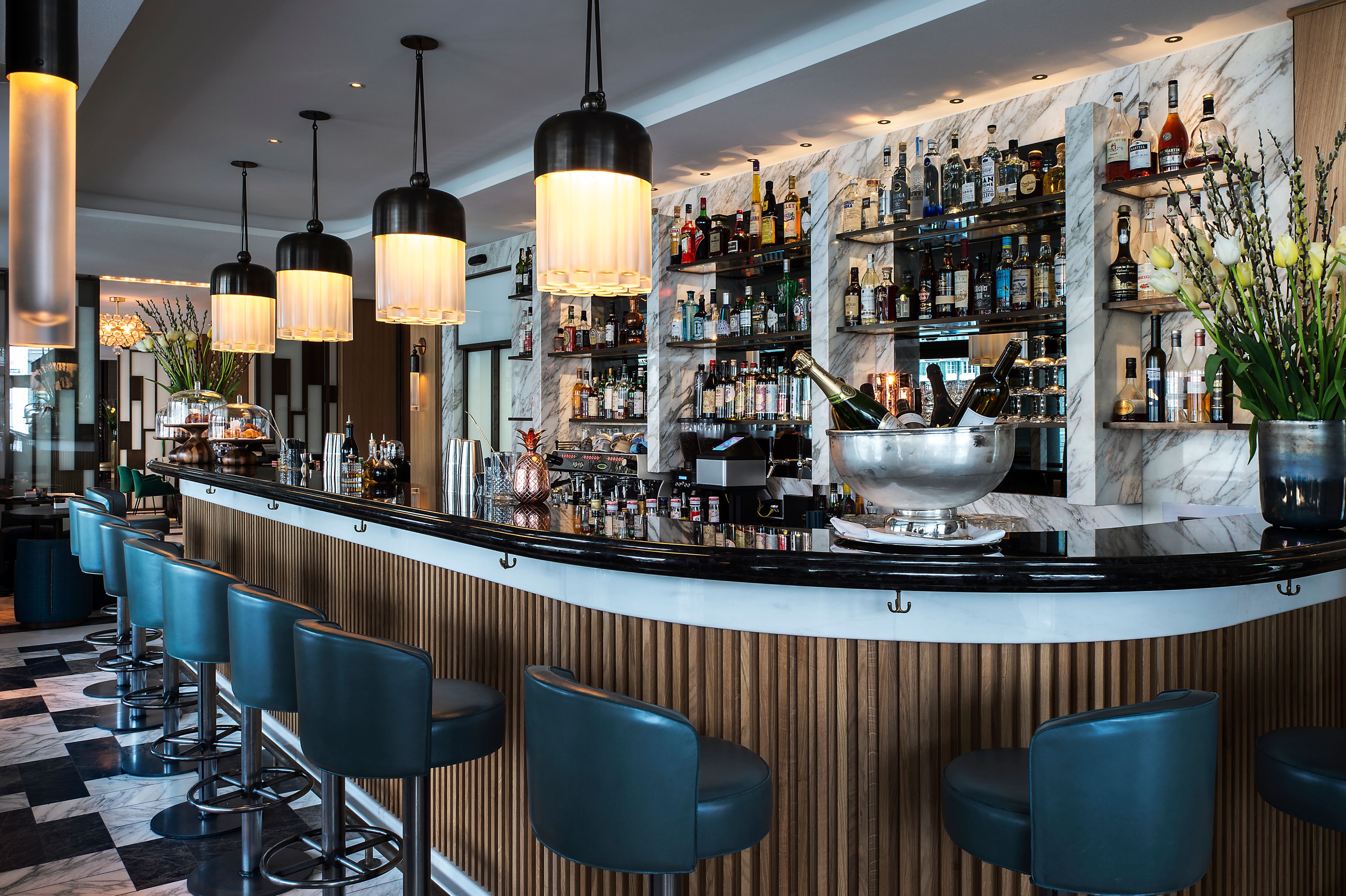 a bar with a row of chairs and a silver bowl