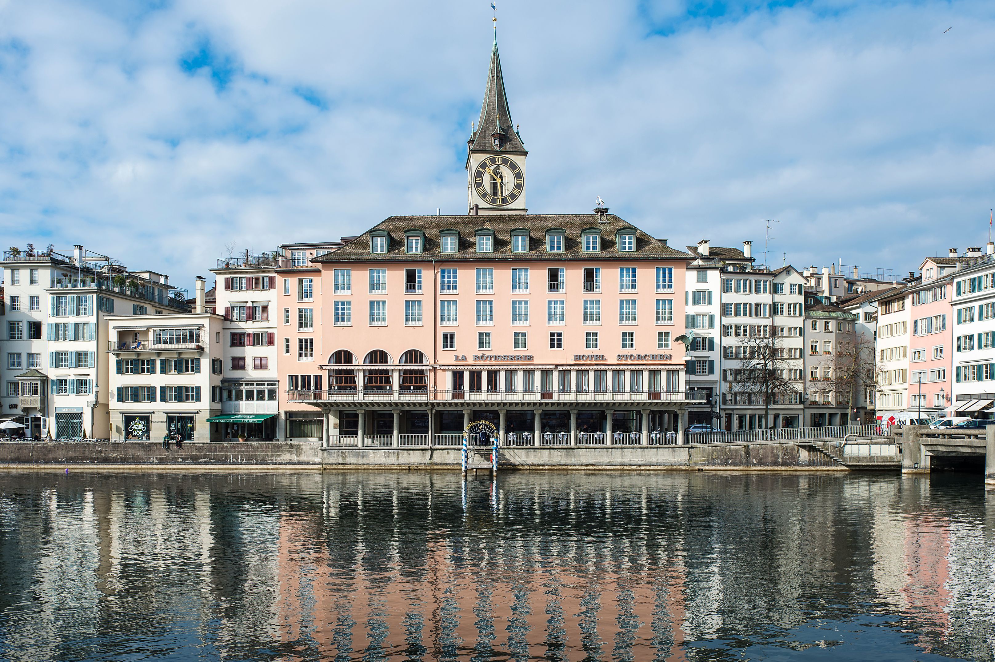 a building with a clock tower and a body of water