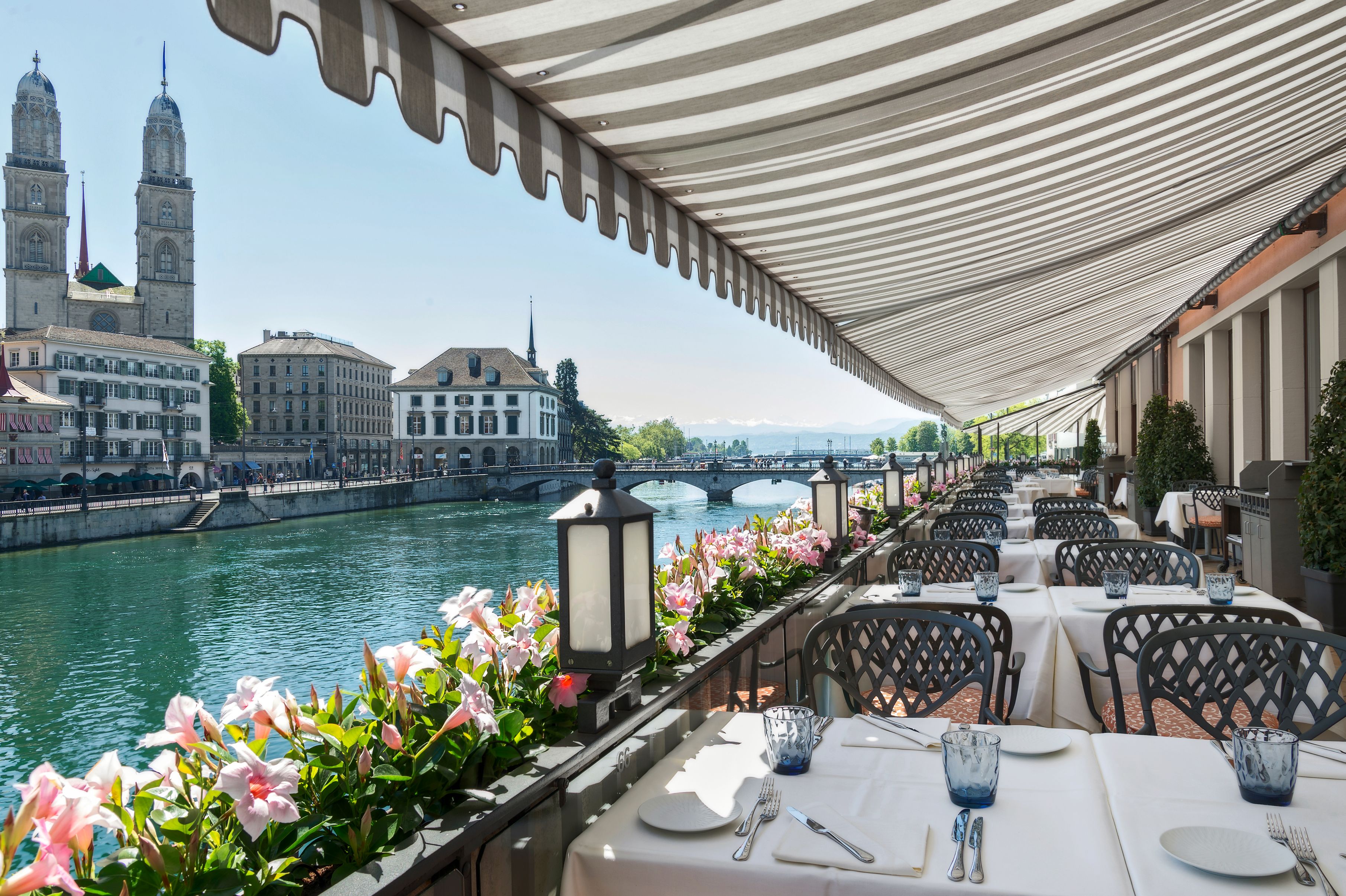 a restaurant with tables and chairs and flowers on a terrace