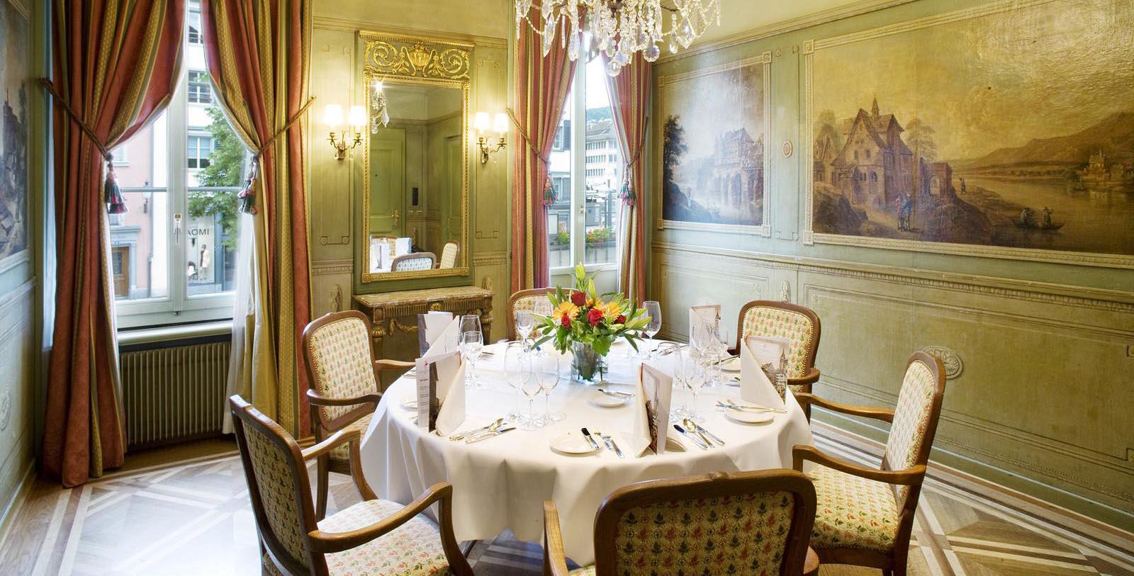 a dining room with a table set with chairs and a chandelier