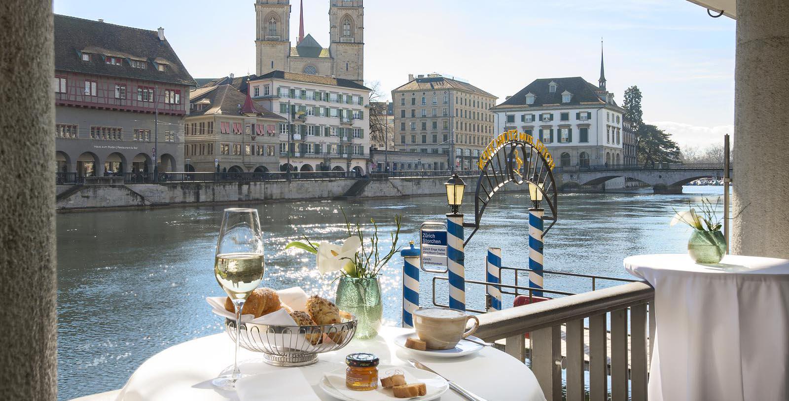 a table with food and wine on it by a river