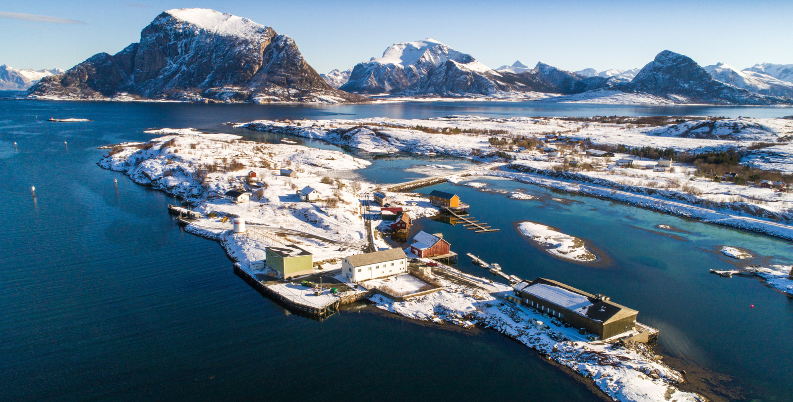 a small village on a lake surrounded by snow