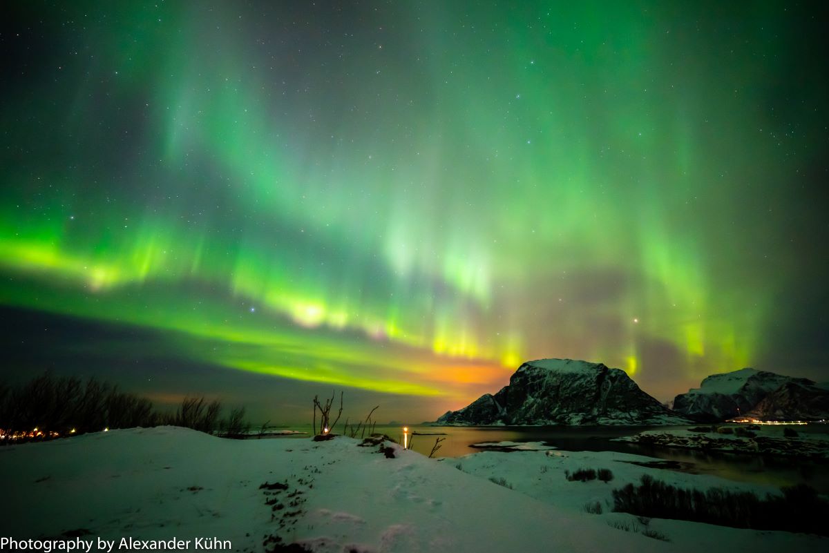 green lights in the sky over a snowy landscape