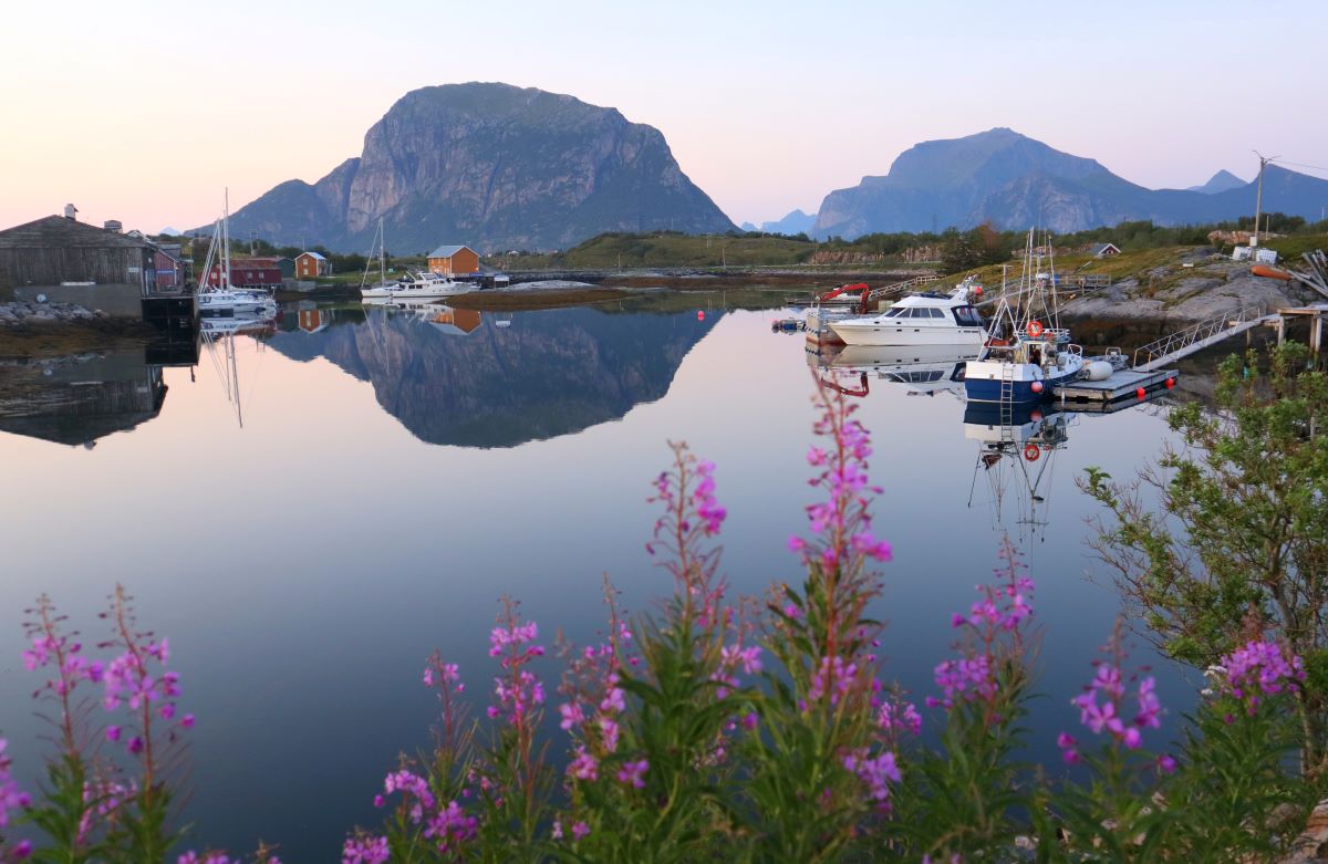 a body of water with boats and mountains in the background