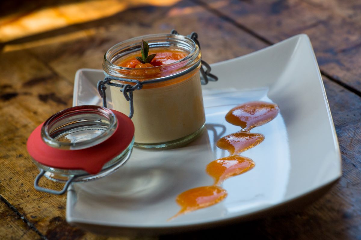 a glass jar with a sauce on a white plate