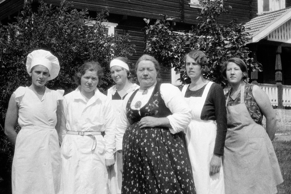 a group of women in aprons standing together