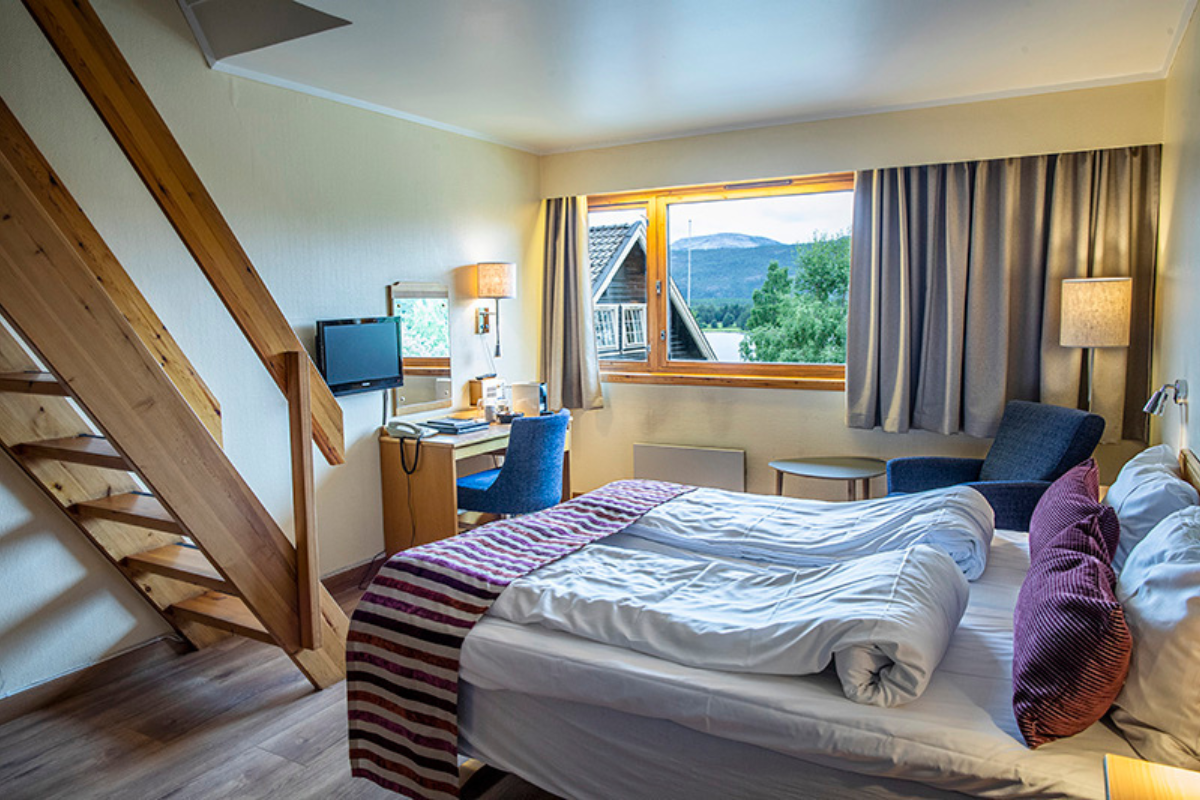 a bedroom with a bed and a desk and a window
