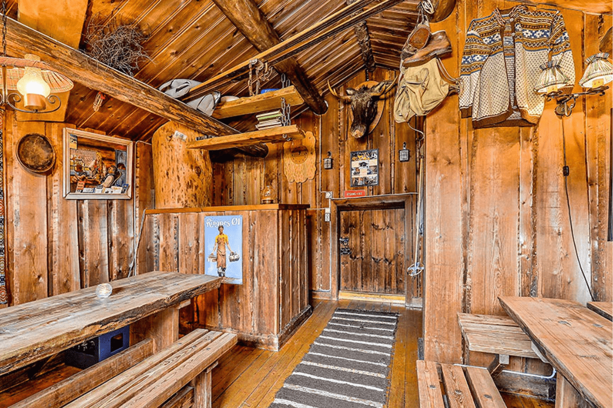 a room with wood walls and a table and benches