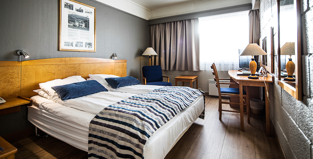 a room with a bed and a table and chairs
