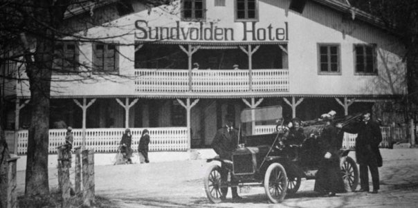 a man in a car in front of a hotel