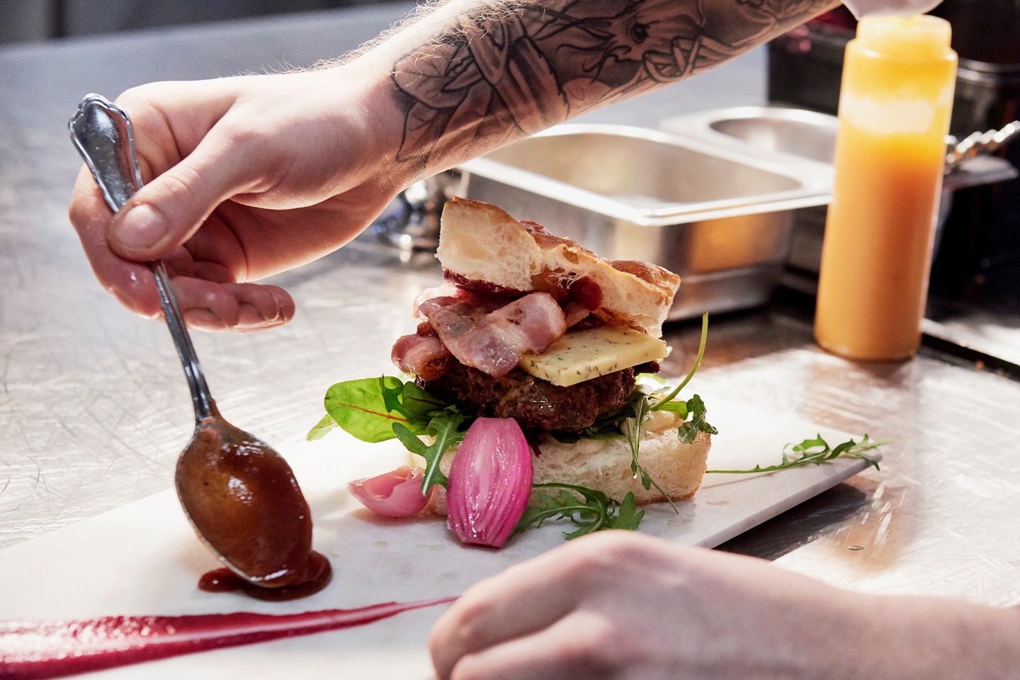 a person putting sauce on a sandwich