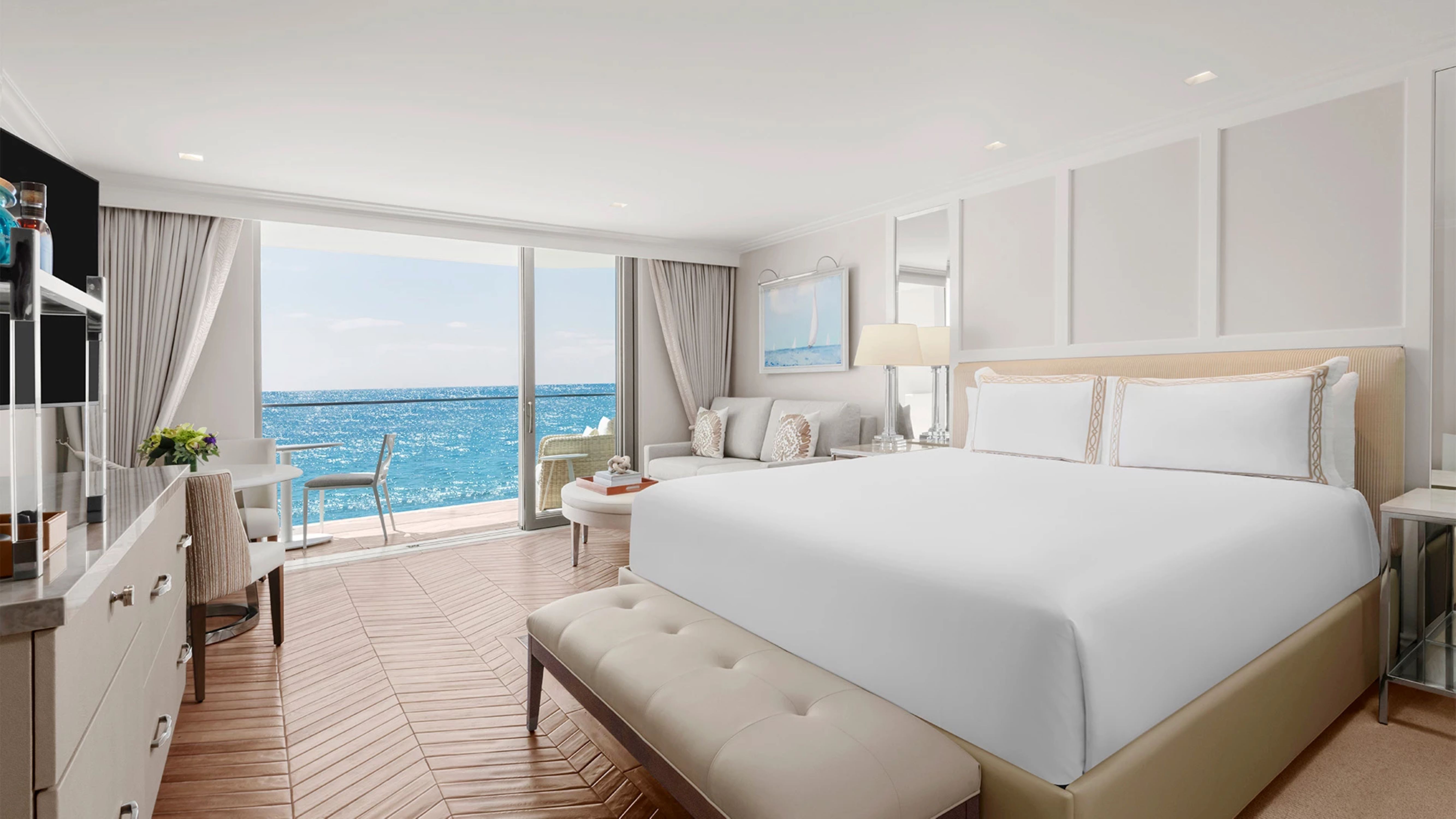 a room with a large bed and a large window overlooking the ocean