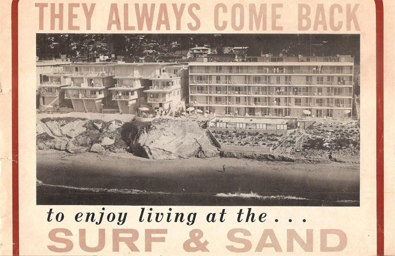 a black and white photo of a beach and buildings