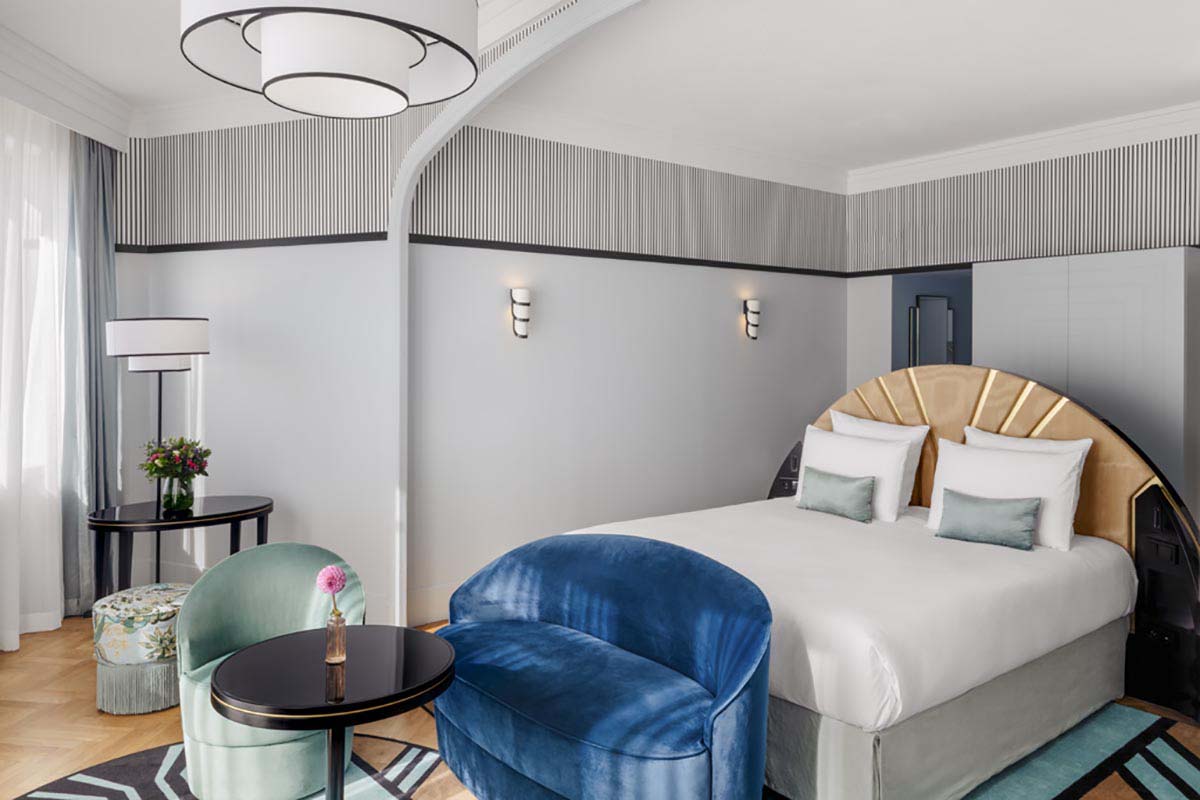 a room with a bed and chairs