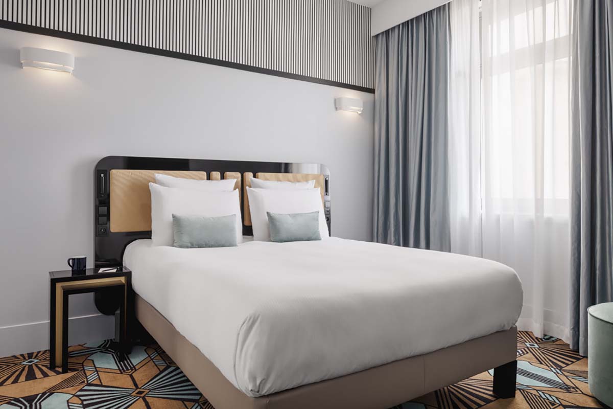 a bed with white sheets and pillows in a room