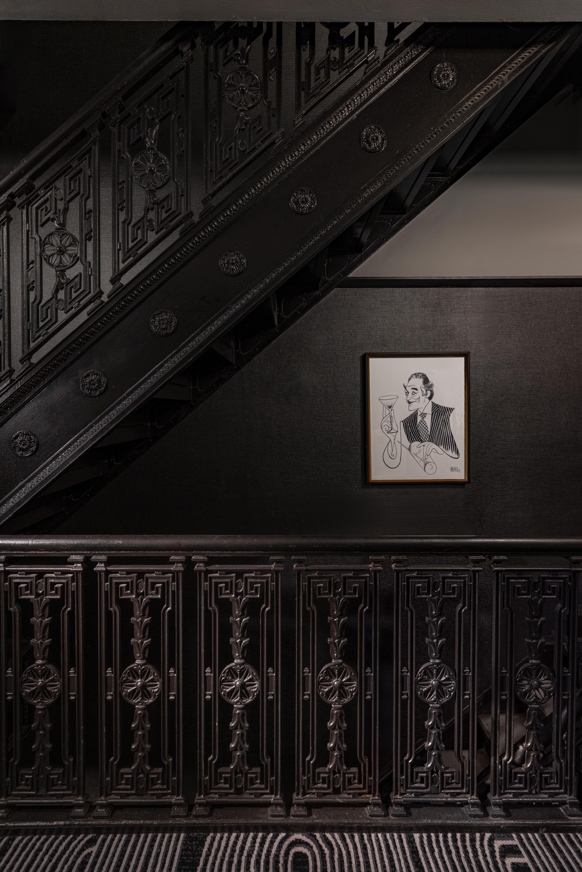 a black staircase with a picture on the wall