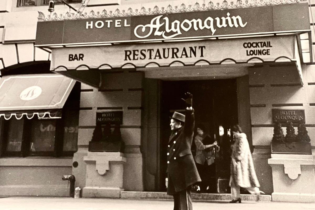 a man in uniform waving in front of a restaurant