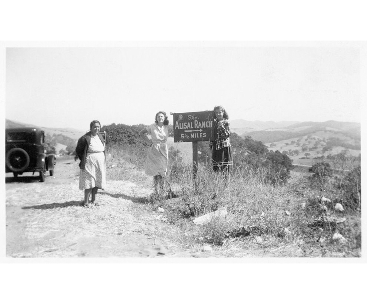 a group of women standing next to a sign