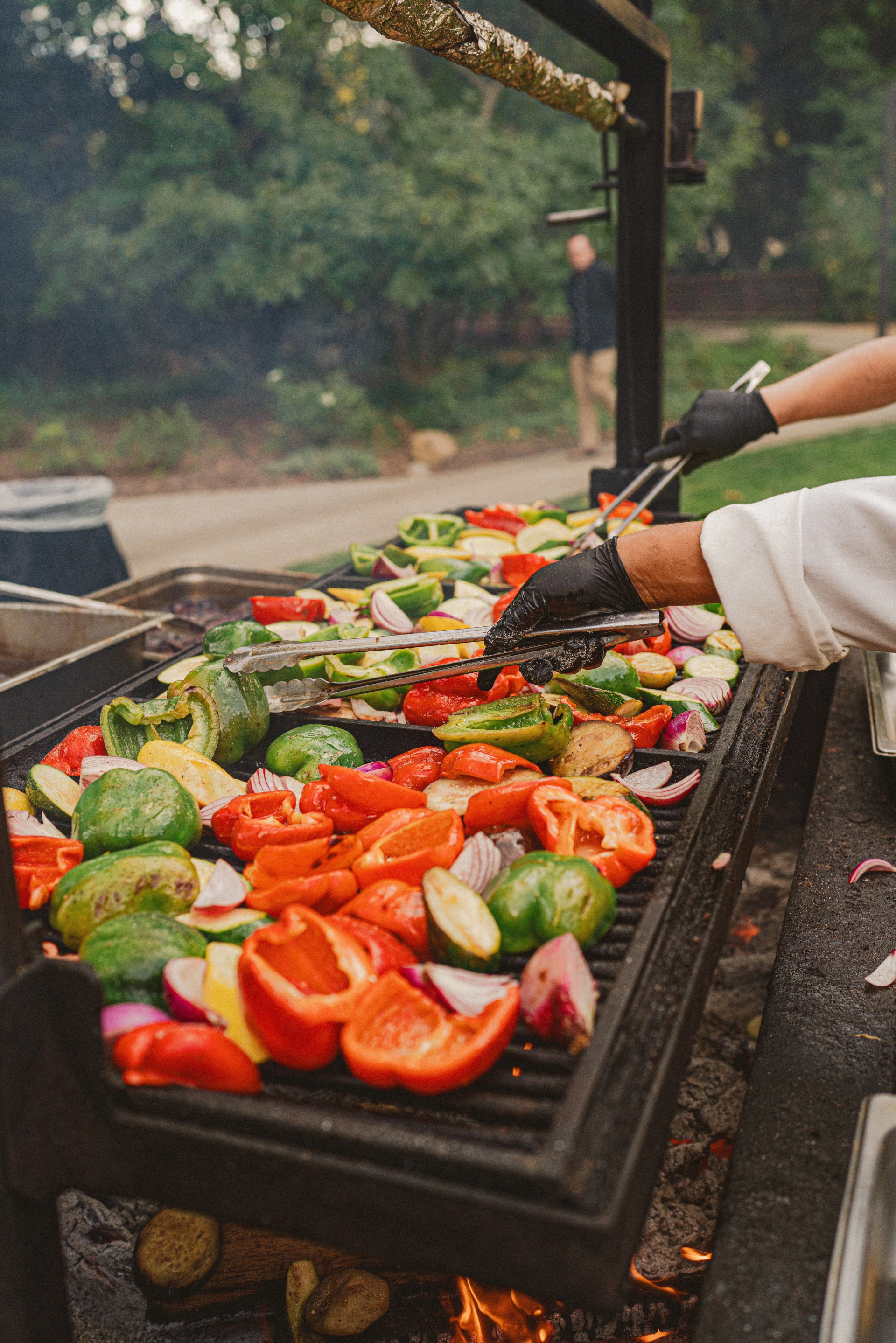 a person cooking vegetables on a grill