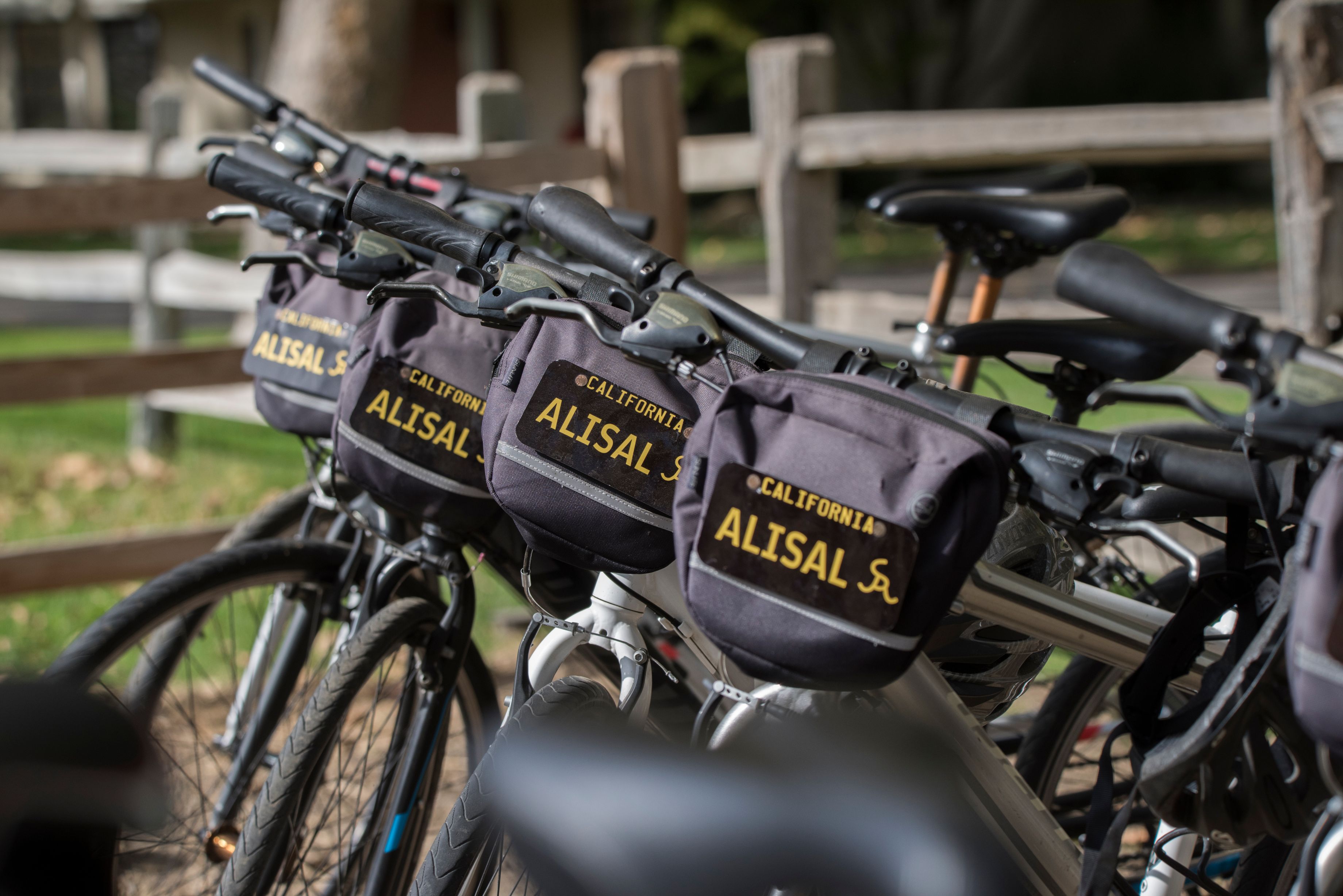 a row of bicycles with bags on the handlebars
